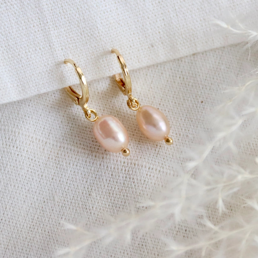 Crafted from high-quality 14K gold-plated material, these earrings are both durable and long-lasting, ensuring they will be a treasured addition to your jewellery collection. The blush pink pearl pendant adds a touch of femininity and glamour, making them the perfect choice for any occasion. It is said that pearls are good for calming your mind and symbolize perfection, good fortune, wealth and good luck.