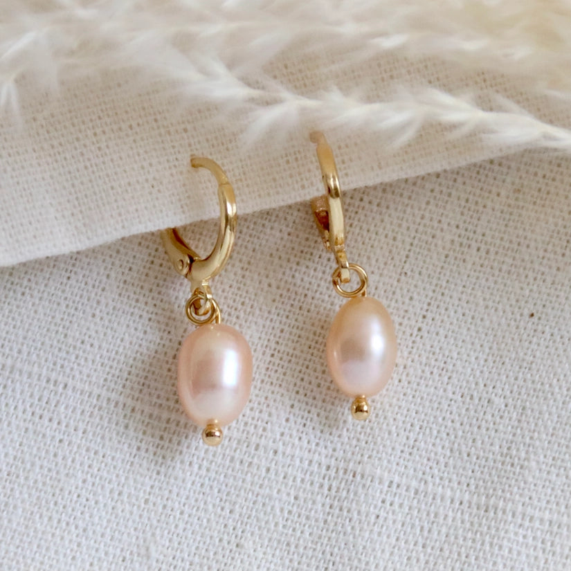 Crafted from high-quality 14K gold-plated material, these earrings are both durable and long-lasting, ensuring they will be a treasured addition to your jewellery collection. The blush pink pearl pendant adds a touch of femininity and glamour, making them the perfect choice for any occasion. It is said that pearls are good for calming your mind and symbolize perfection, good fortune, wealth and good luck.