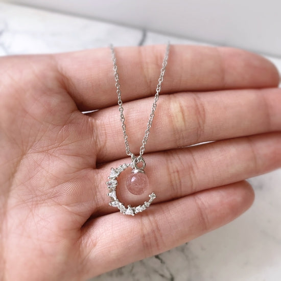 Introducing our stunning Strawberry Crystal Moon Pendant Necklace, handcrafted with natural Strawberry Quartz and a crystal Moon pendant, hanging on a Sterling Silver Chain. This unique necklace is the perfect addition to any jewellery collection and is sure to turn heads.