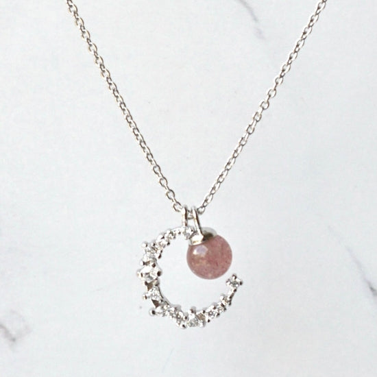 Introducing our stunning Strawberry Crystal Moon Pendant Necklace, handcrafted with natural Strawberry Quartz and a crystal Moon pendant, hanging on a Sterling Silver Chain. This unique necklace is the perfect addition to any jewellery collection and is sure to turn heads.