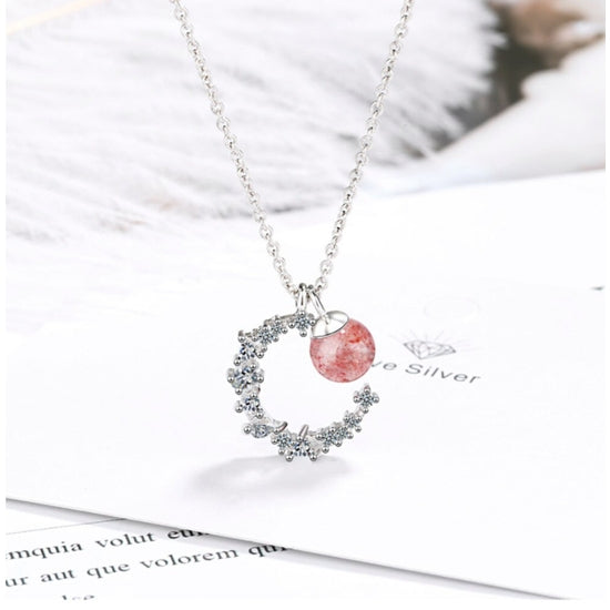 Introducing our stunning Strawberry Crystal Moon Pendant Necklace, handcrafted with natural Strawberry Quartz and a crystal Moon pendant, hanging on a Sterling Silver Chain. This unique necklace is the perfect addition to any jewellery collection and is sure to turn heads.