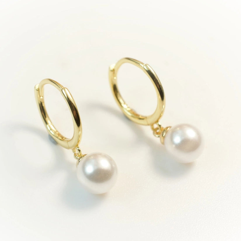 Elevate your jewellery collection with the Jolie Pearl Earrings. These beautiful earrings are crafted from high-quality 925 sterling silver. They are also available in 18K gold plating, giving them a luxurious and timeless appeal. The secure push back closure ensures that they stay in place all day long and they are nickel-free, making them suitable for those with sensitive skin. 