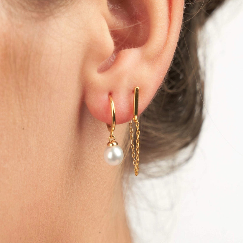 Elevate your jewellery collection with the Jolie Pearl Earrings. These beautiful earrings are crafted from high-quality 925 sterling silver. They are also available in 18K gold plating, giving them a luxurious and timeless appeal. The secure push back closure ensures that they stay in place all day long and they are nickel-free, making them suitable for those with sensitive skin. 